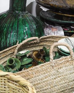 tamegroute green candle holders in a large basket in marrakech