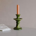 orange st eval candle sitting in a green tamegroute candle stick