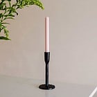 black iron candlestick holding a rose pink dinner candle by st eval we are nomads