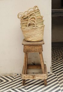 stack of moroccan market baskets on a wooden stool