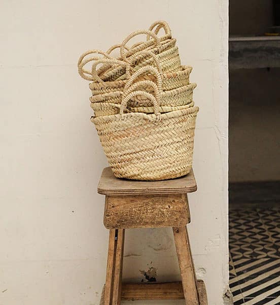 stack of moroccan market baskets on a wooden stool