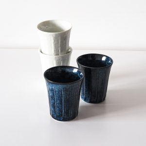 Japanese white and navy blue ceramic cups on a white background