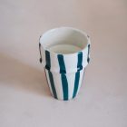 A ceramic coffee mug featuring vertical blue and white stripes, placed on a neutral surface. Perfect for travel or everyday use, combining style and functionality.