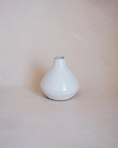 Simple small ceramic white vase on a plain background